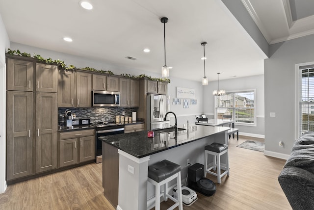 176 Cross Park Dr, Georgetown, KY 40324 - kitchen with appliances with stainless steel finishes, light wood-type flooring, a kitchen breakfast bar, a kitchen island with sink, and backsplash