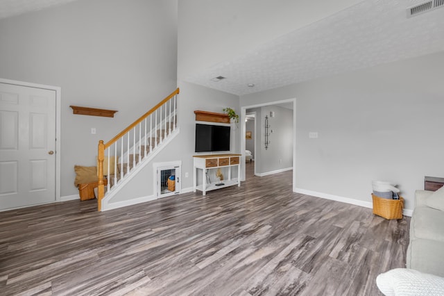 1701 Keating Dr, Louisville, KY 40245 - unfurnished living room with wood finished floors, stairway, a towering ceiling, and a textured ceiling