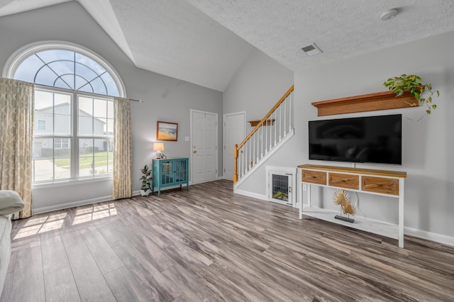 1701 Keating Dr, Louisville, KY 40245 - unfurnished living room with wood finished floors, stairs, a textured ceiling, and high vaulted ceiling