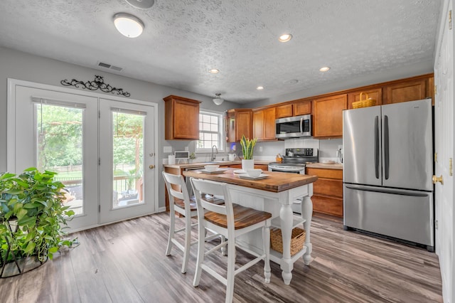 1701 Keating Dr, Louisville, KY 40245 - kitchen featuring appliances with stainless steel finishes, brown cabinets, light wood finished floors, a textured ceiling, and recessed lighting