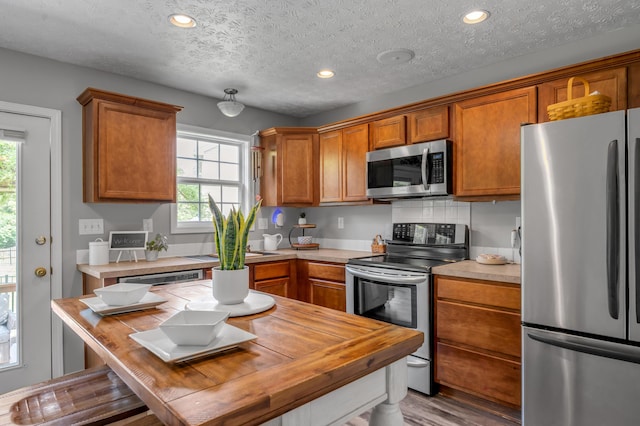 1701 Keating Dr, Louisville, KY 40245 - kitchen with stainless steel appliances, healthy amount of natural light, light countertops, brown cabinets, and a textured ceiling