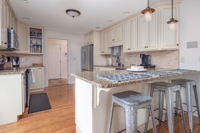 5045 Mccowans Ferry Rd, Versailles, KY 40383 - kitchen with stainless steel appliances, a peninsula, backsplash, cream cabinets, and a breakfast bar