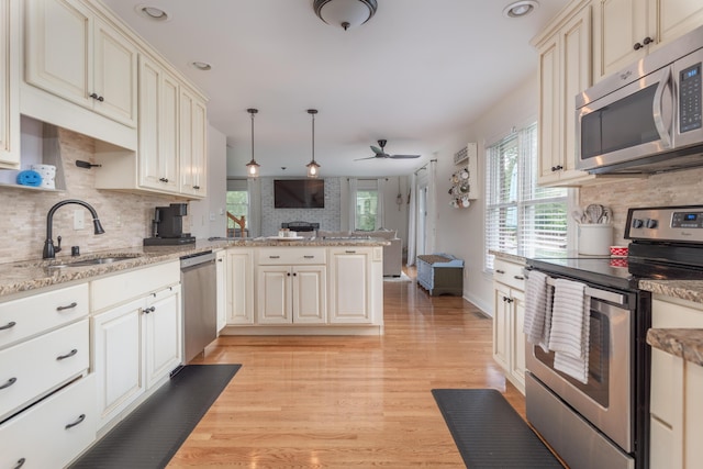 5045 Mccowans Ferry Rd, Versailles, KY 40383 - kitchen featuring appliances with stainless steel finishes, a peninsula, backsplash, ceiling fan, and open floor plan