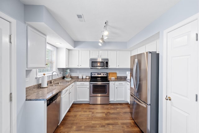 2193 Birkdale Dr, Lexington, KY 40509 - kitchen featuring appliances with stainless steel finishes, white cabinetry, dark wood finished floors, dark stone countertops, and track lighting