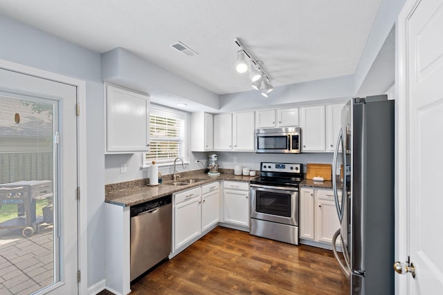 2193 Birkdale Dr, Lexington, KY 40509 - kitchen featuring appliances with stainless steel finishes, white cabinetry, dark wood-style floors, dark stone countertops, and track lighting
