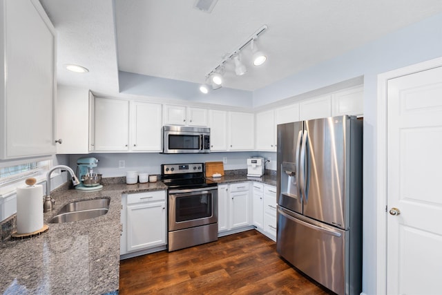 2193 Birkdale Dr, Lexington, KY 40509 - kitchen with appliances with stainless steel finishes, white cabinets, dark stone countertops, dark wood-style floors, and rail lighting