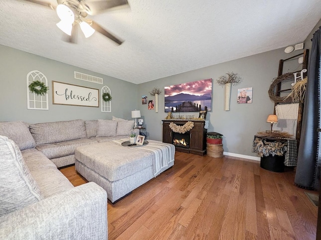 109 Edwards Ct, Lancaster, KY 40444 - living room featuring wood finished floors, a ceiling fan, a textured ceiling, and a lit fireplace
