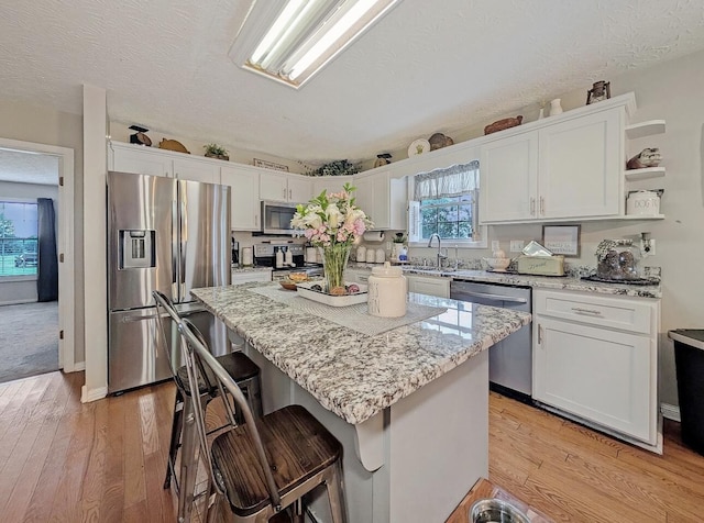 109 Edwards Ct, Lancaster, KY 40444 - kitchen featuring appliances with stainless steel finishes, white cabinets, light stone countertops, light wood-style flooring, and a textured ceiling