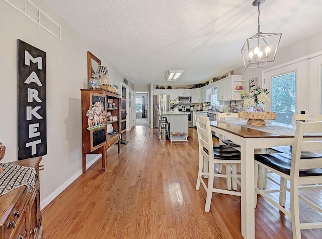 109 Edwards Ct, Lancaster, KY 40444 - dining space featuring a chandelier, light wood-type flooring, and a textured ceiling