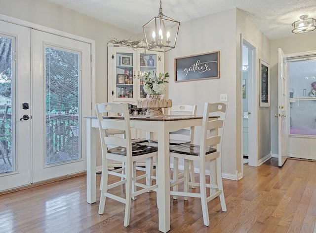 109 Edwards Ct, Lancaster, KY 40444 - dining space with french doors, light wood-style flooring, a chandelier, and a textured ceiling