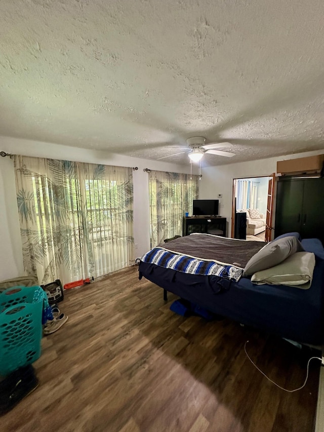 449 Johns Rd, Jabez, KY 42544 - bedroom featuring wood finished floors, a textured ceiling, a ceiling fan, and a wall mounted AC