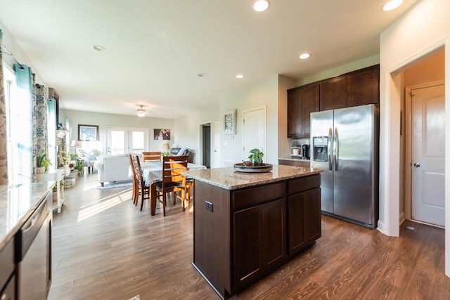 126 Mollie Way, Georgetown, KY 40324 - kitchen with appliances with stainless steel finishes, dark brown cabinetry, dark wood finished floors, a kitchen island, and light stone countertops