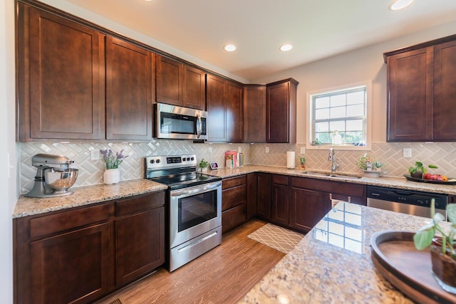 126 Mollie Way, Georgetown, KY 40324 - kitchen featuring stainless steel appliances, light stone countertops, light wood-style floors, tasteful backsplash, and recessed lighting