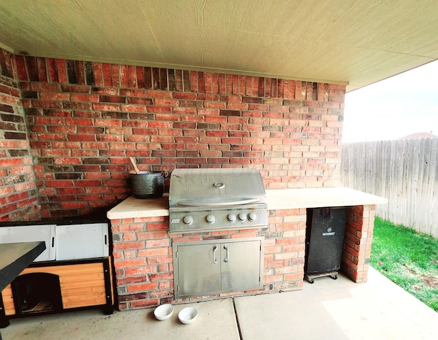 view of patio / terrace featuring an outdoor kitchen, a grill, and fence