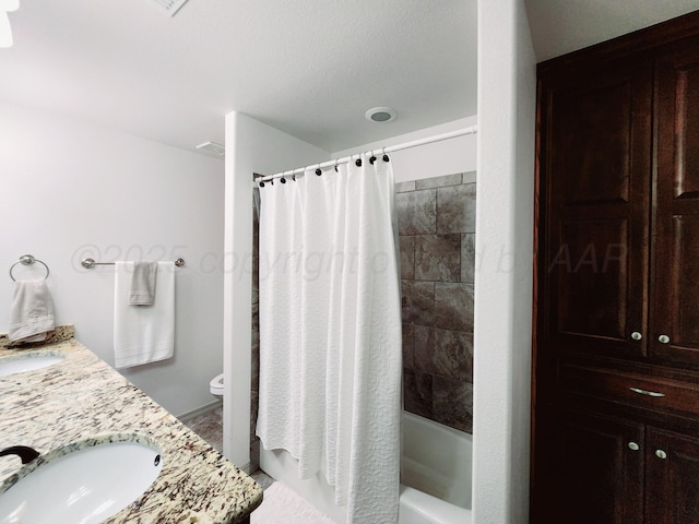 bathroom featuring shower / bath combo, toilet, a sink, and double vanity