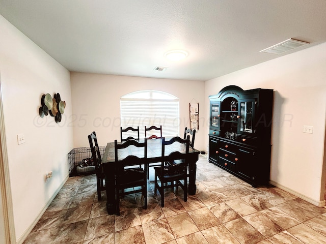 dining room featuring visible vents, stone finish flooring, and baseboards