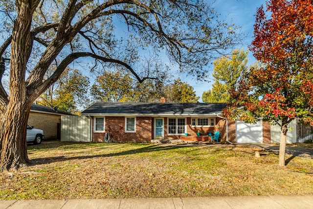 ranch-style house featuring a garage and a front yard