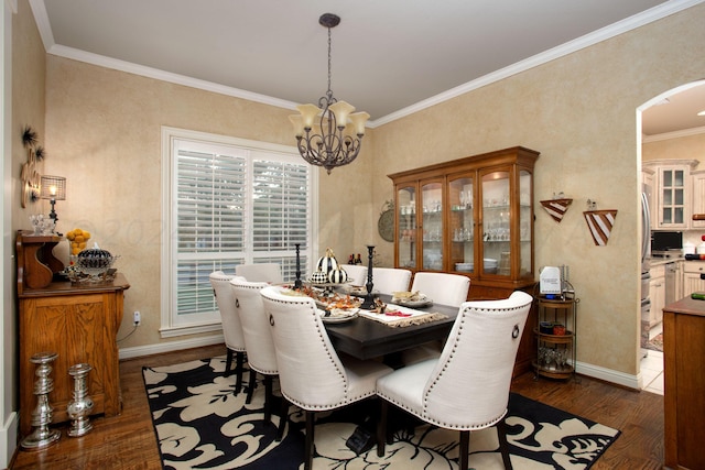 7705 New England Pkwy, Amarillo, TX 79119 - dining room featuring dark wood-style floors, baseboards, arched walkways, ornamental molding, and a notable chandelier