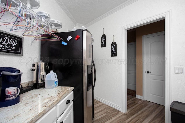6106 Purple Sage Cir, Amarillo, TX 79124 - kitchen with crown molding, light wood-style floors, white cabinetry, stainless steel refrigerator with ice dispenser, and baseboards