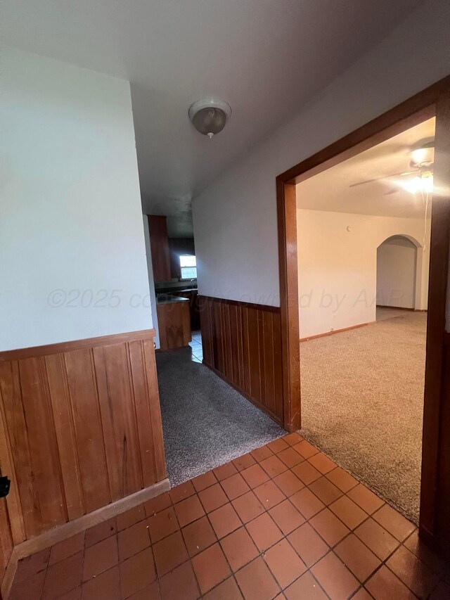 109 Ranger St, Hereford, TX 79045 - hall with carpet floors, a wainscoted wall, arched walkways, and wood walls