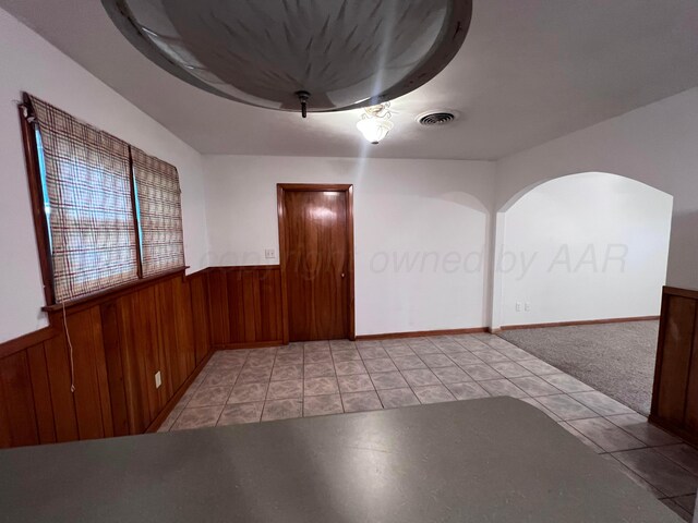 109 Ranger St, Hereford, TX 79045 - empty room with a wainscoted wall, wooden walls, and light tile patterned floors