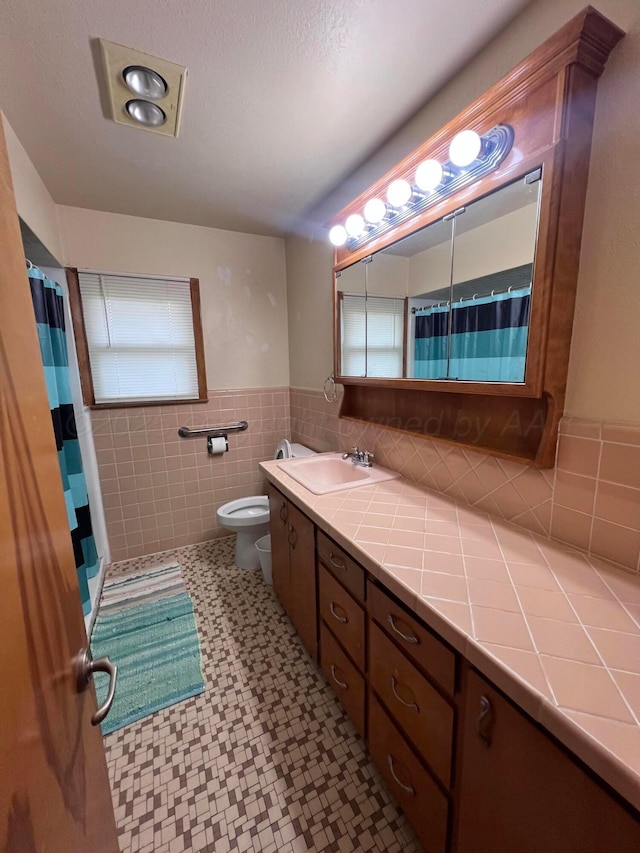 109 Ranger St, Hereford, TX 79045 - bathroom with vanity, tile walls, a shower with curtain, toilet, and tile patterned floors
