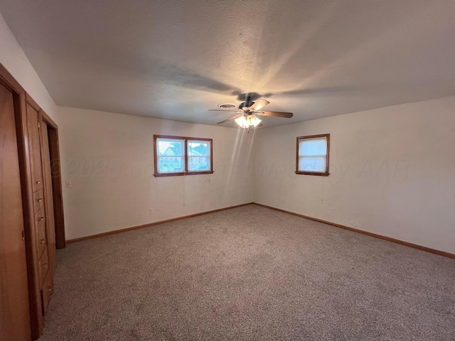 109 Ranger St, Hereford, TX 79045 - unfurnished bedroom featuring light colored carpet, multiple windows, baseboards, and ceiling fan