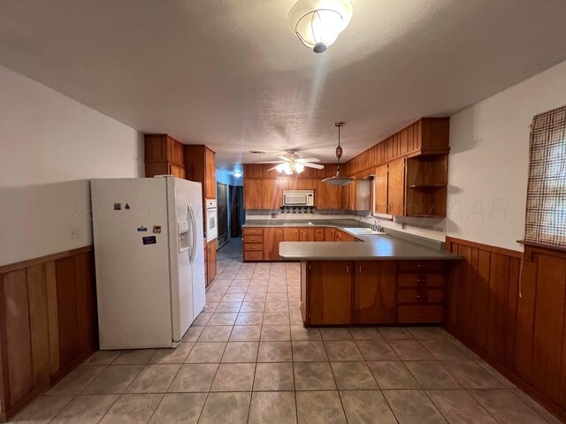 109 Ranger St, Hereford, TX 79045 - kitchen with white appliances, a peninsula, a sink, brown cabinets, and ceiling fan