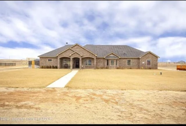 ranch-style home featuring a front lawn