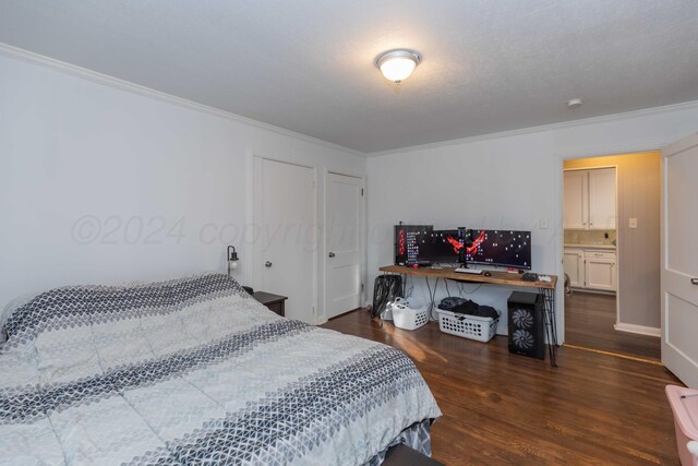 bedroom featuring ensuite bathroom, crown molding, and dark hardwood / wood-style flooring