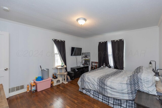 bedroom featuring dark hardwood / wood-style floors, a textured ceiling, and crown molding