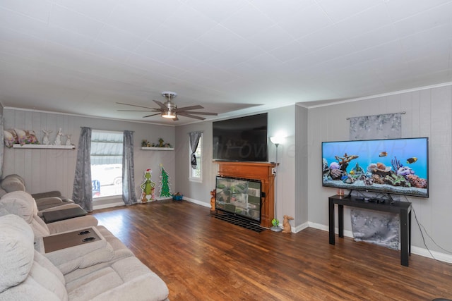 living room featuring ceiling fan, wooden walls, dark hardwood / wood-style floors, and crown molding