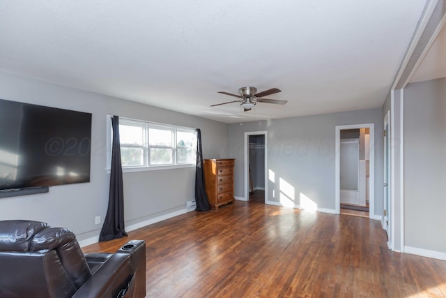 living room featuring dark wood-type flooring and ceiling fan