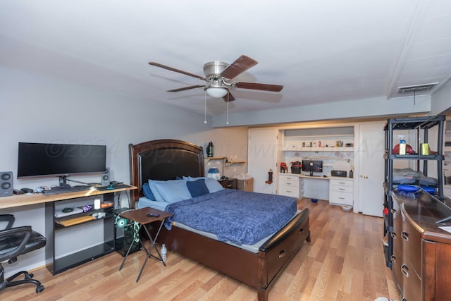 bedroom featuring built in desk, ceiling fan, and light hardwood / wood-style flooring