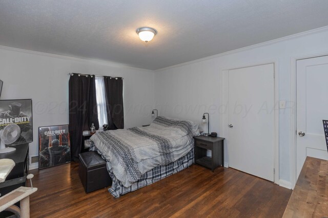 bedroom featuring dark hardwood / wood-style floors, a textured ceiling, and crown molding