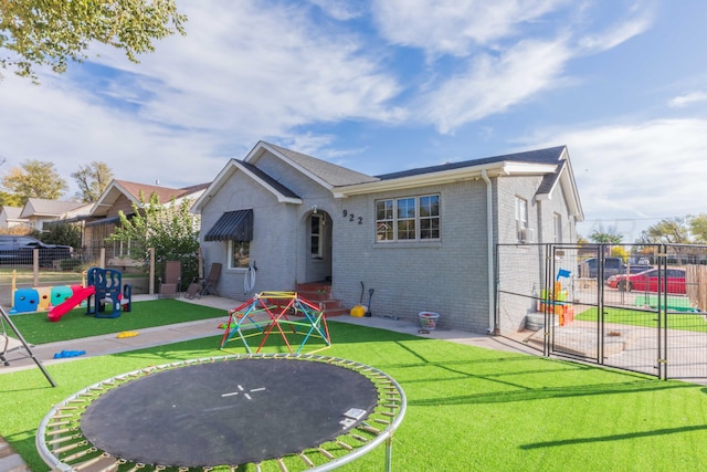 rear view of property with a playground and a yard