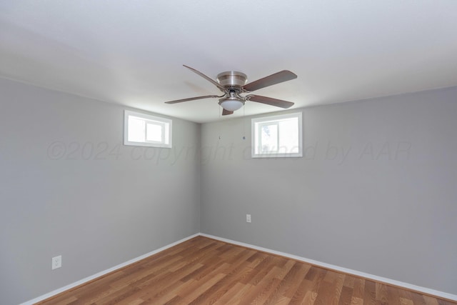 basement featuring a wealth of natural light, hardwood / wood-style floors, and ceiling fan