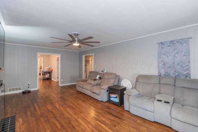 living room featuring dark wood-type flooring, ceiling fan, and crown molding