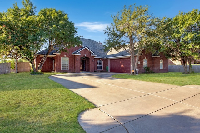 single story home featuring fence, concrete driveway, an attached garage, a front yard, and brick siding