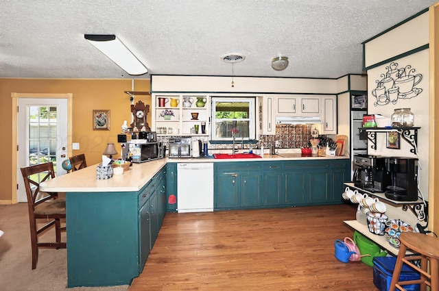 6005 Gainsborough Rd, Amarillo, TX 79106 - kitchen featuring stainless steel appliances, a sink, a peninsula, blue cabinets, and a textured ceiling