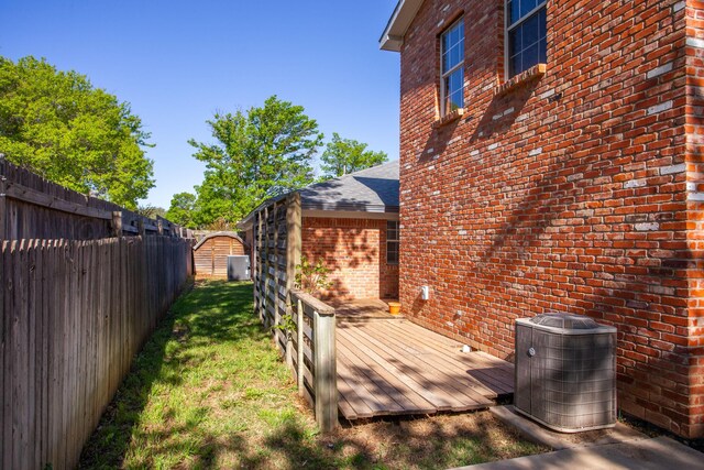 3925 Gatewood St, Amarillo, TX 79109 - view of yard with a wooden deck, a fenced backyard, central AC unit, and a storage unit