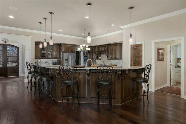 7908 London Ct, Amarillo, TX 79119 - kitchen with dark brown cabinetry, appliances with stainless steel finishes, decorative backsplash, and dark wood-style floors