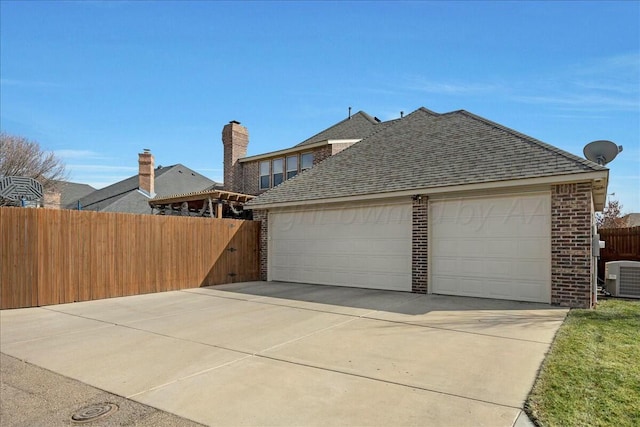 7908 London Ct, Amarillo, TX 79119 - view of side of home featuring brick siding, fence, cooling unit, concrete driveway, and roof with shingles