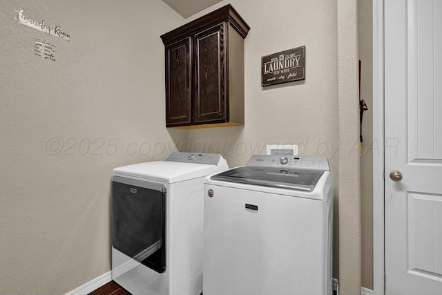 washroom featuring cabinet space, baseboards, and separate washer and dryer