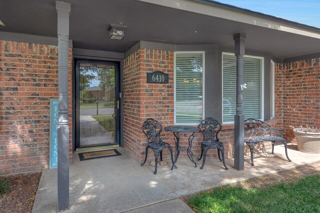 6410 Hamstead Dr, Amarillo, TX 79109 - view of exterior entry featuring brick siding and a porch