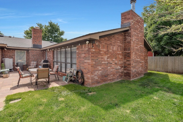 6410 Hamstead Dr, Amarillo, TX 79109 - rear view of house with a chimney, a patio area, and brick siding