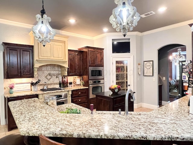 7507 Continental Pkwy, Amarillo, TX 79119 - kitchen with appliances with stainless steel finishes, a chandelier, arched walkways, ornamental molding, and backsplash