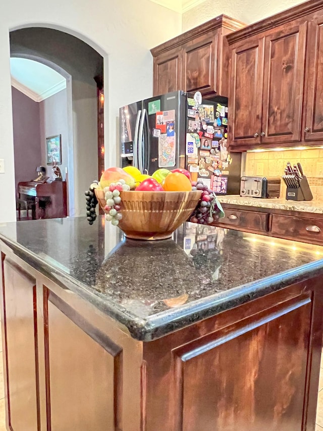 7507 Continental Pkwy, Amarillo, TX 79119 - kitchen featuring stainless steel fridge with ice dispenser, crown molding, arched walkways, decorative backsplash, and a center island