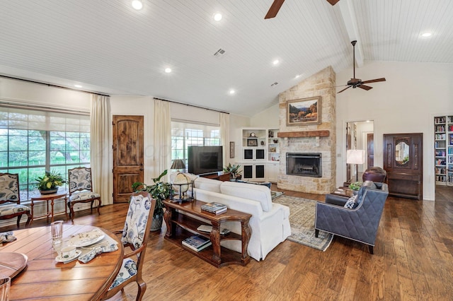 living room featuring ceiling fan, wood-type flooring, a stone fireplace, and high vaulted ceiling