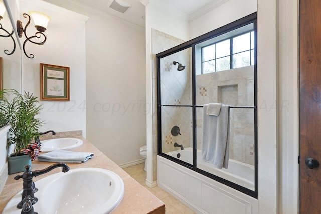 full bathroom with tile patterned flooring, vanity, crown molding, bath / shower combo with glass door, and toilet